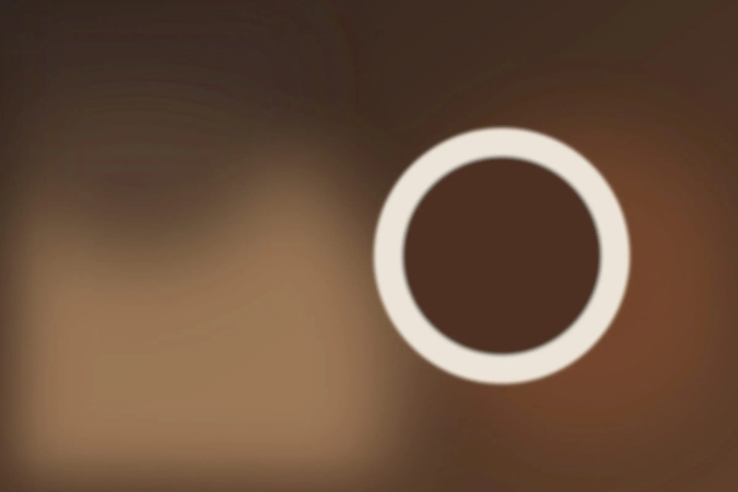 A cup of black coffee seen from above on a warm wooden table